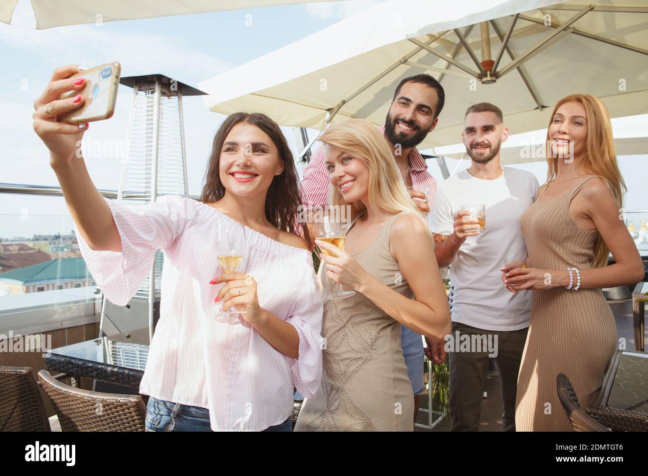 Group of friends taking selfies on a smart phone together during ...