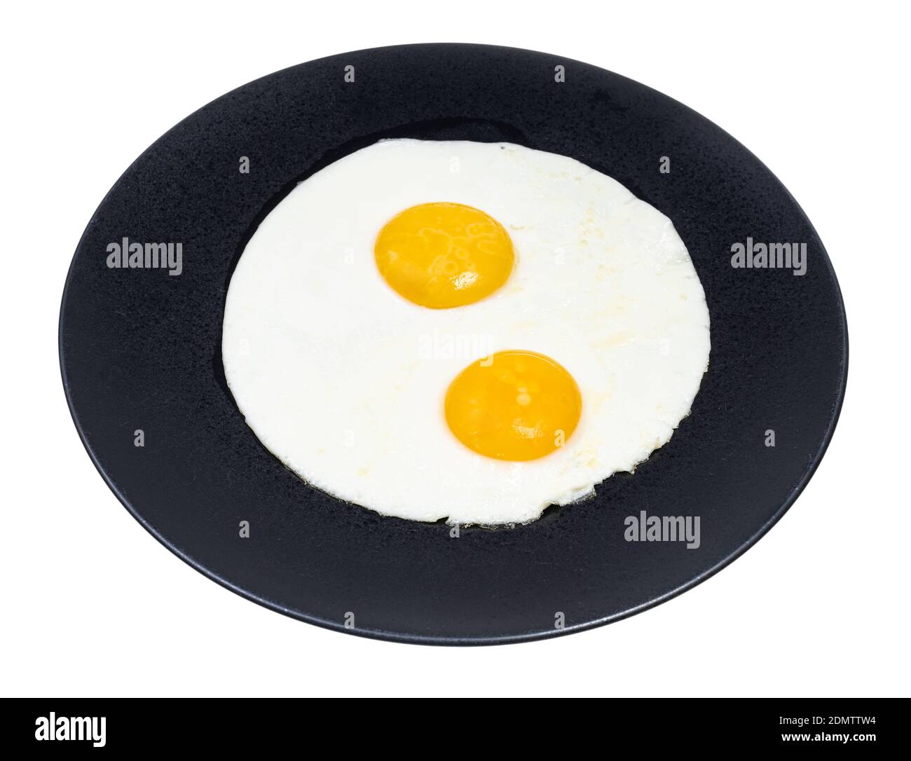 two fried eggs on black plate isolated on white background Stock Photo
