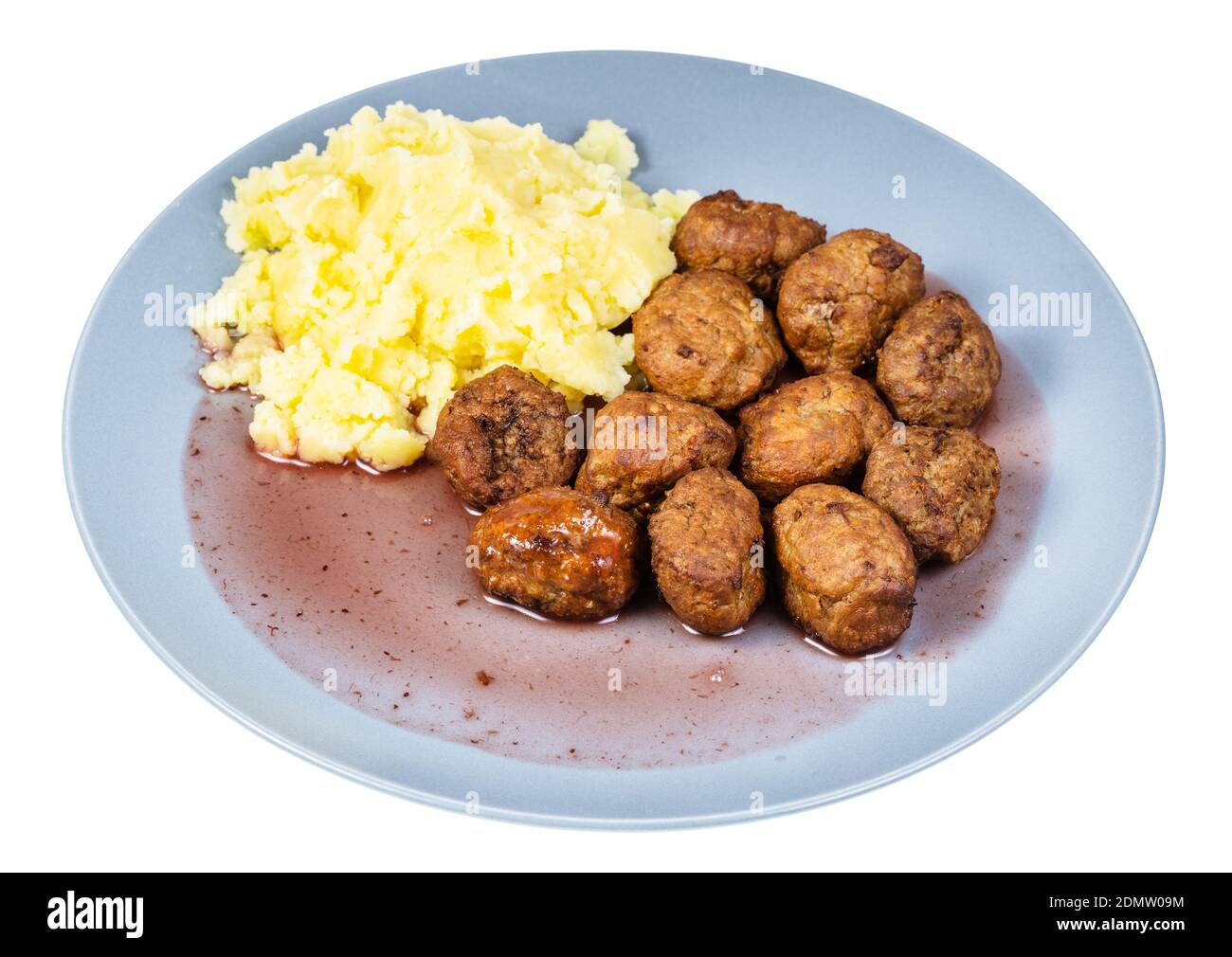 portion of fried swedish meatballs with lingonberry sauce and mashed potatoes on blue plate isolated on white background Stock Photo