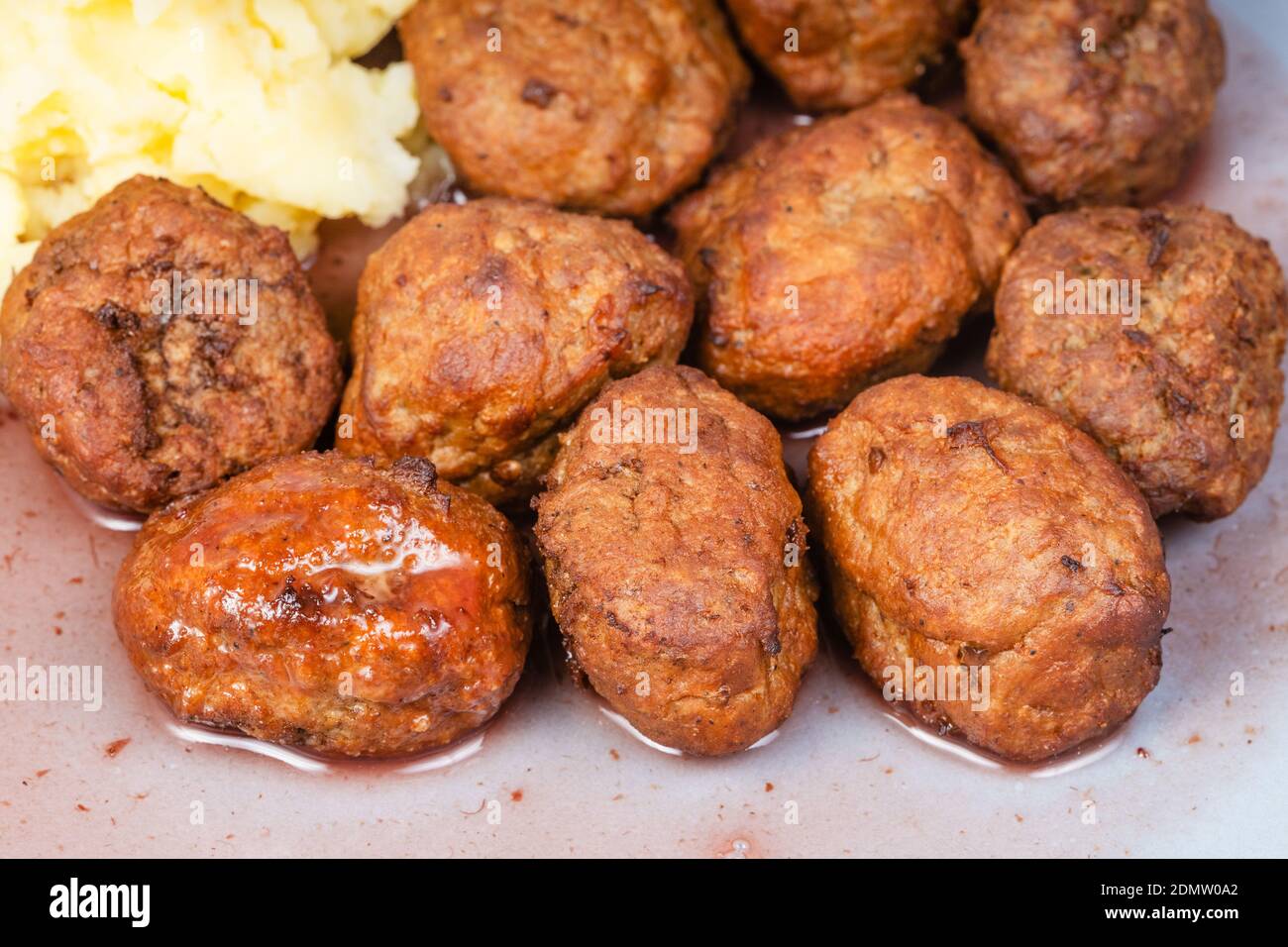 cooked swedish meatballs with lingonberry sauce and mashed potatoes on blue plate close up Stock Photo
