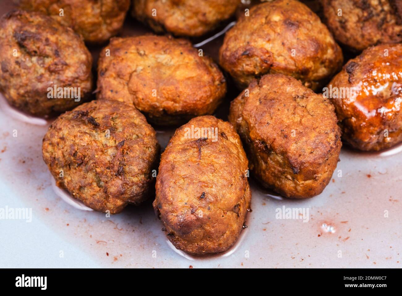 cooked swedish meatballs with lingonberry sauce on blue plate close up Stock Photo