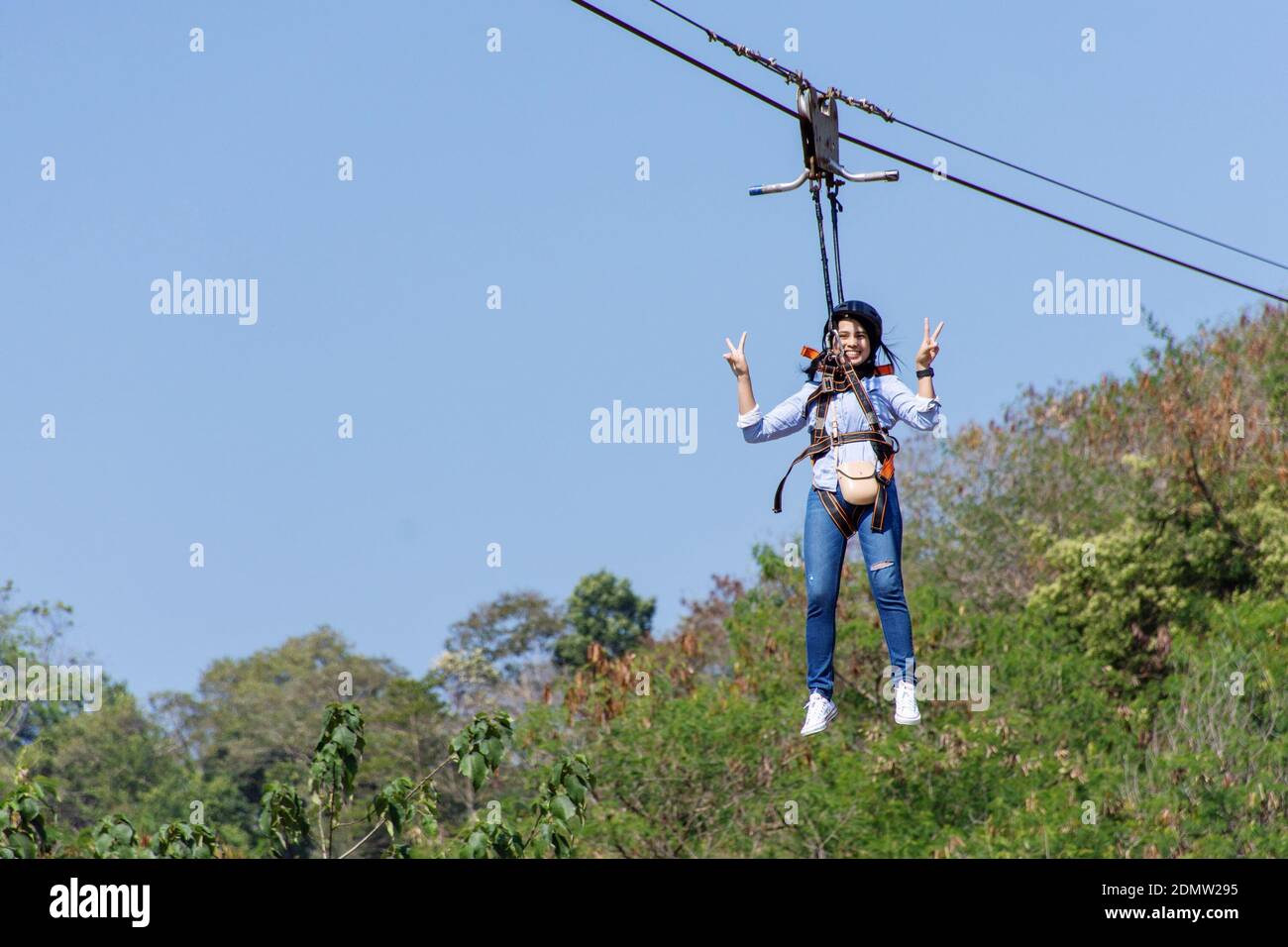 Portrait Of Woman Hanging From Safety Harness While Rappelling Against Sky  Stock Photo - Alamy
