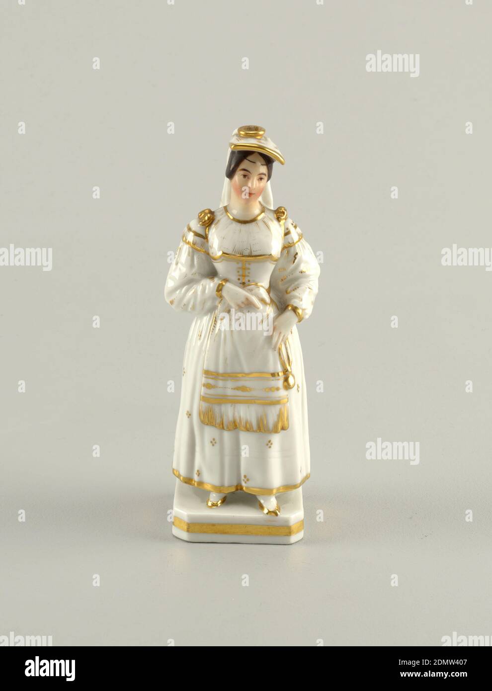 Figures, Glazed and gilt porcelain, A woman dressed in white with gold accents. She wears a fringed apron and carried a gold watch (?), 19th century, ceramics, Decorative Arts, Figures Stock Photo