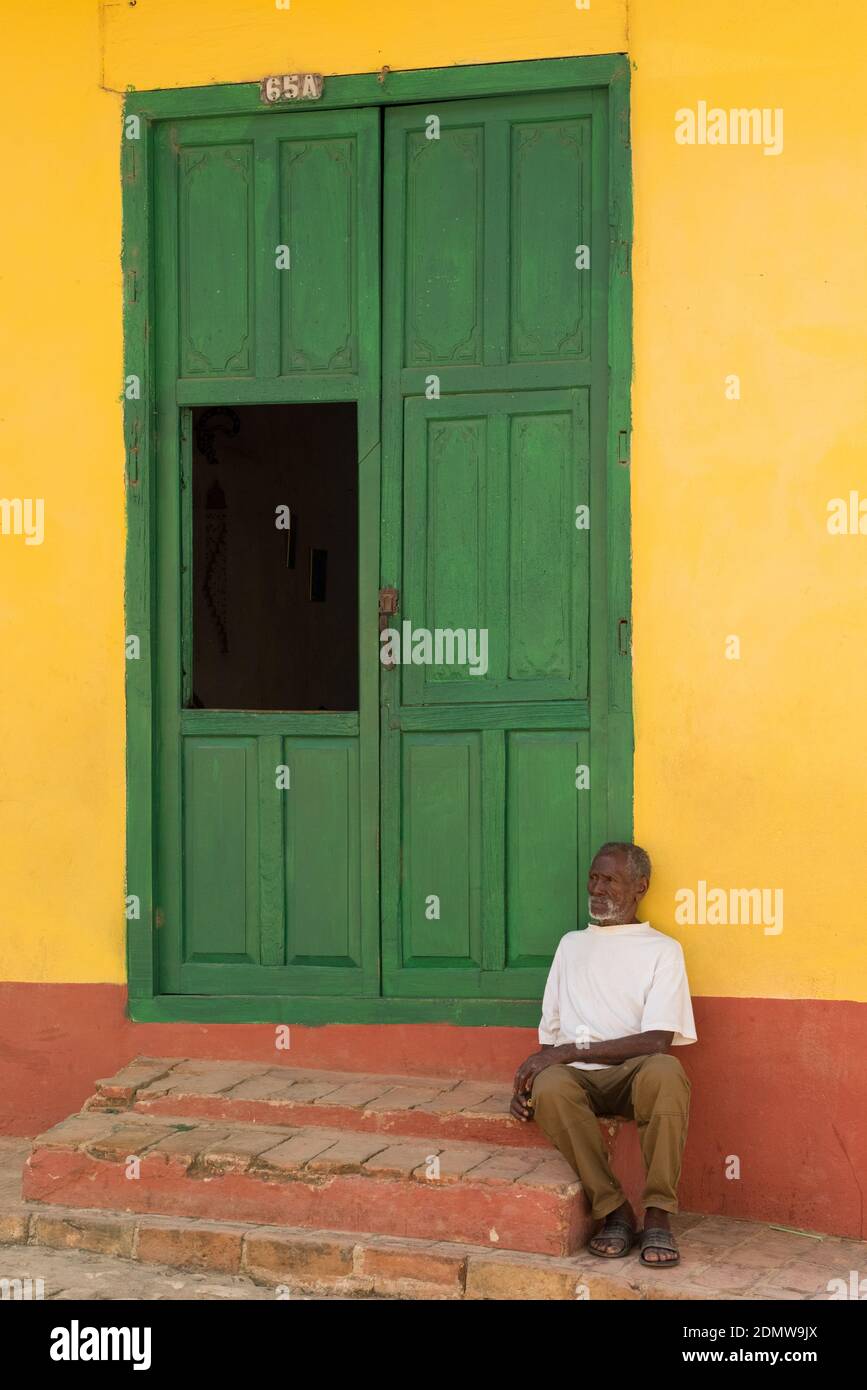 Old man sitting in front of a colonial house, Trinidad Cuba Stock Photo