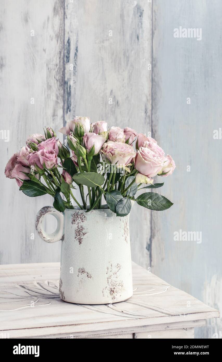 Bouquet of pink roses in ceramic vase. Party decor Stock Photo - Alamy