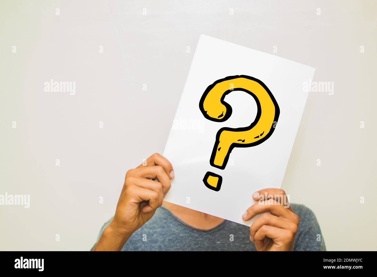 Man Holding Question Mark On Paper Against Gray Background Stock Photo ...