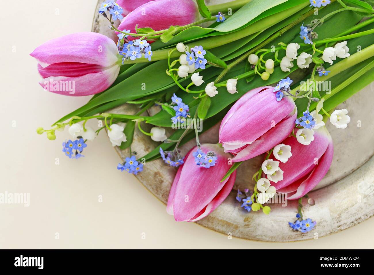 Bouquet of pink tulips, lily of the valley and forget me not flowers. Spring decor Stock Photo