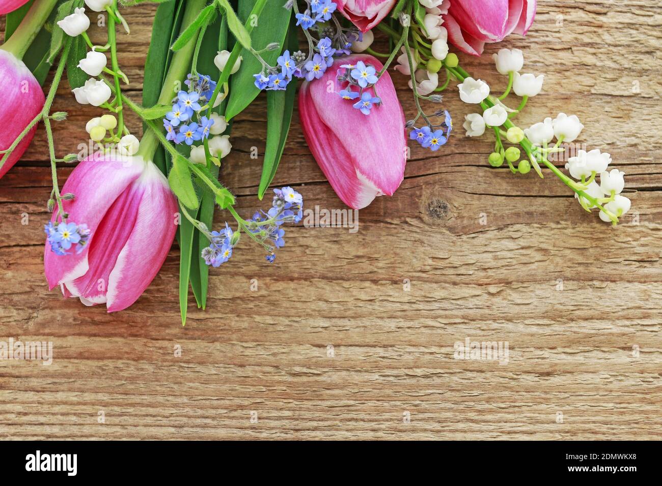 Bouquet of pink tulips, lily of the valley and forget me not flowers. Spring decor Stock Photo
