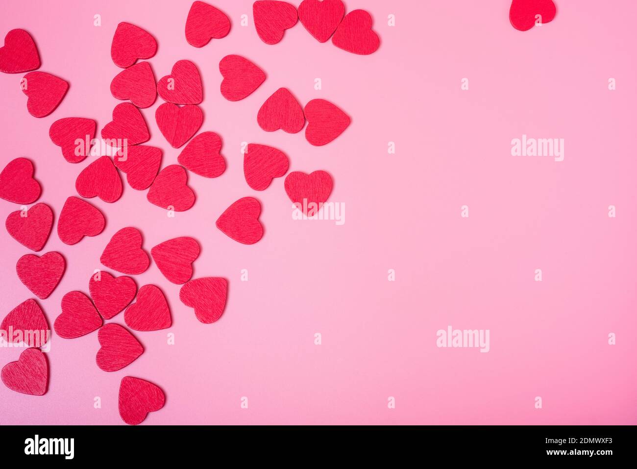 The background of Valentine's day. Small red hearts on a pink background. The concept of love and happiness. Stock Photo