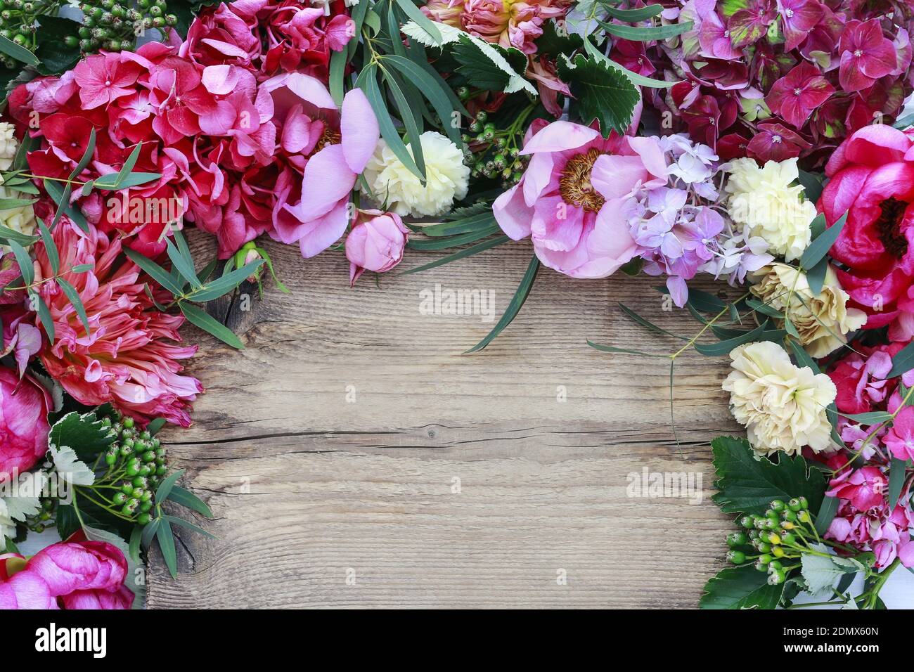 Florist's workspace - flowers and accessories on wooden background. Copy space. Stock Photo