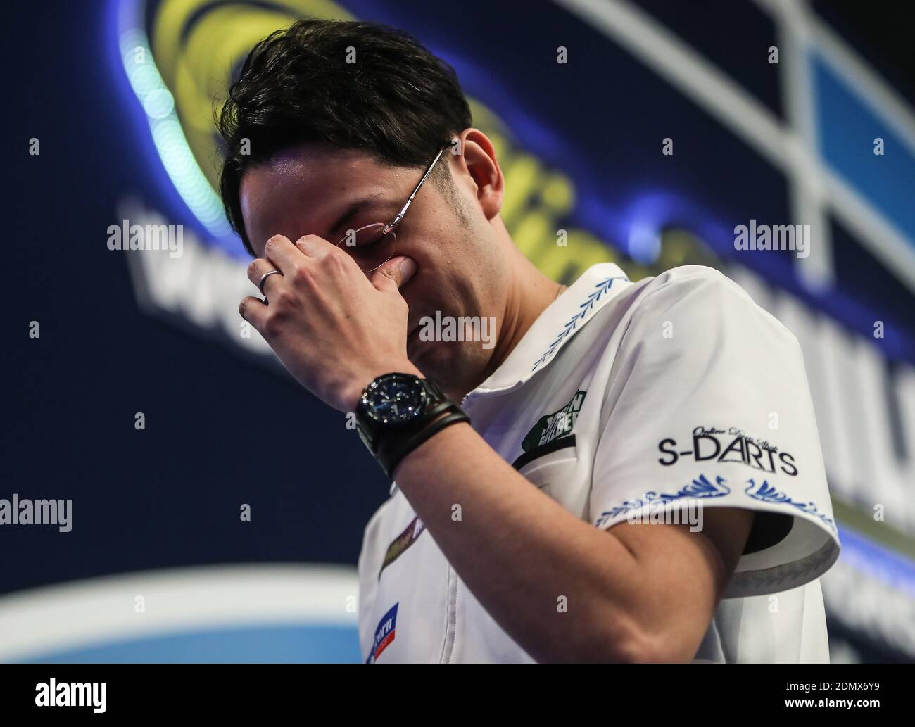 Toru Suzuki holds his head in his hands after losing his match during day three of the William Hill World Darts Championship at Alexandra Palace, London Stock Photo