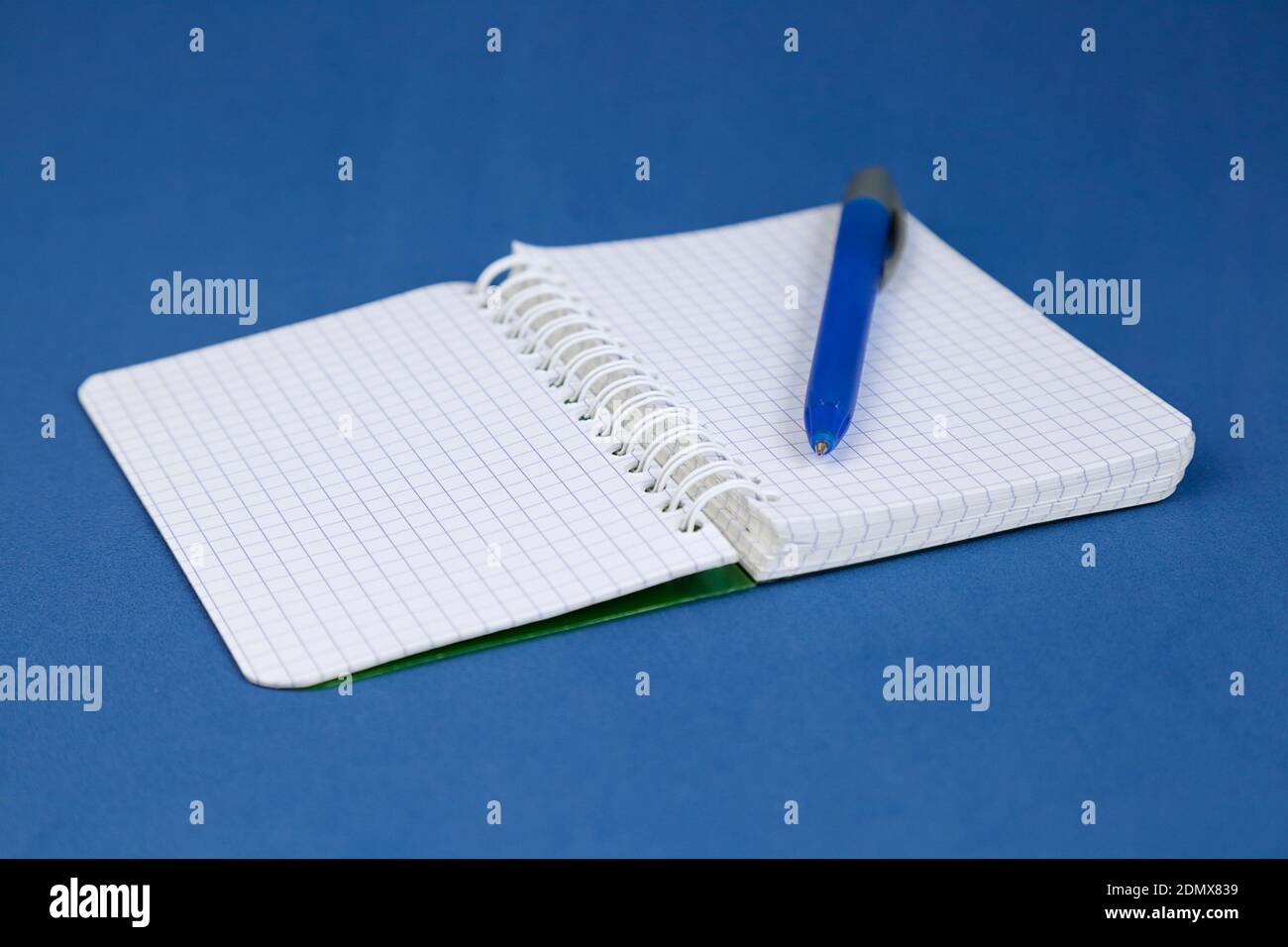 Open notepad and a pen on blue background. Writing concept. Stock Photo