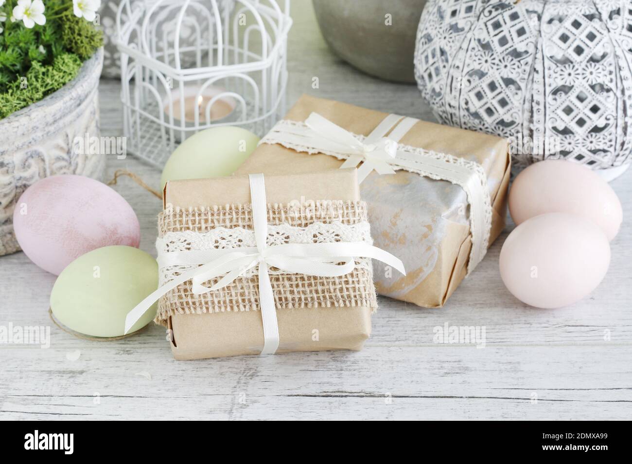 Easrter gifts decorated with lace and ribbon, colorful eggs and saxifraga arendsii (Schneeteppich) flowers. Stock Photo