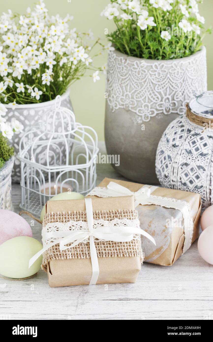 Easrter gifts decorated with lace and ribbon, colorful eggs and saxifraga arendsii (Schneeteppich) flowers. Stock Photo