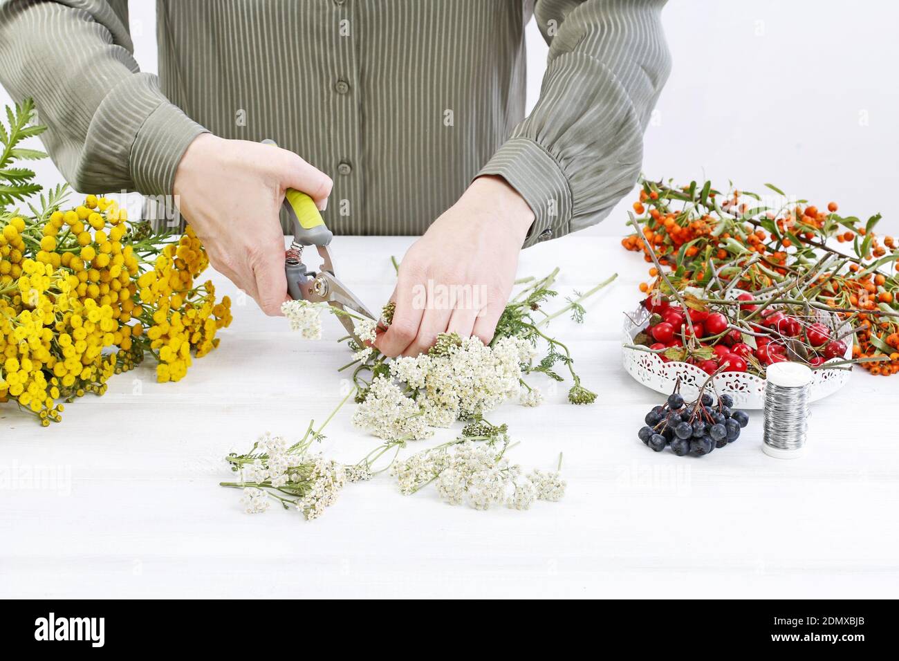 Florist at work: Woman shows how to make autumn wreath with rose hip ...