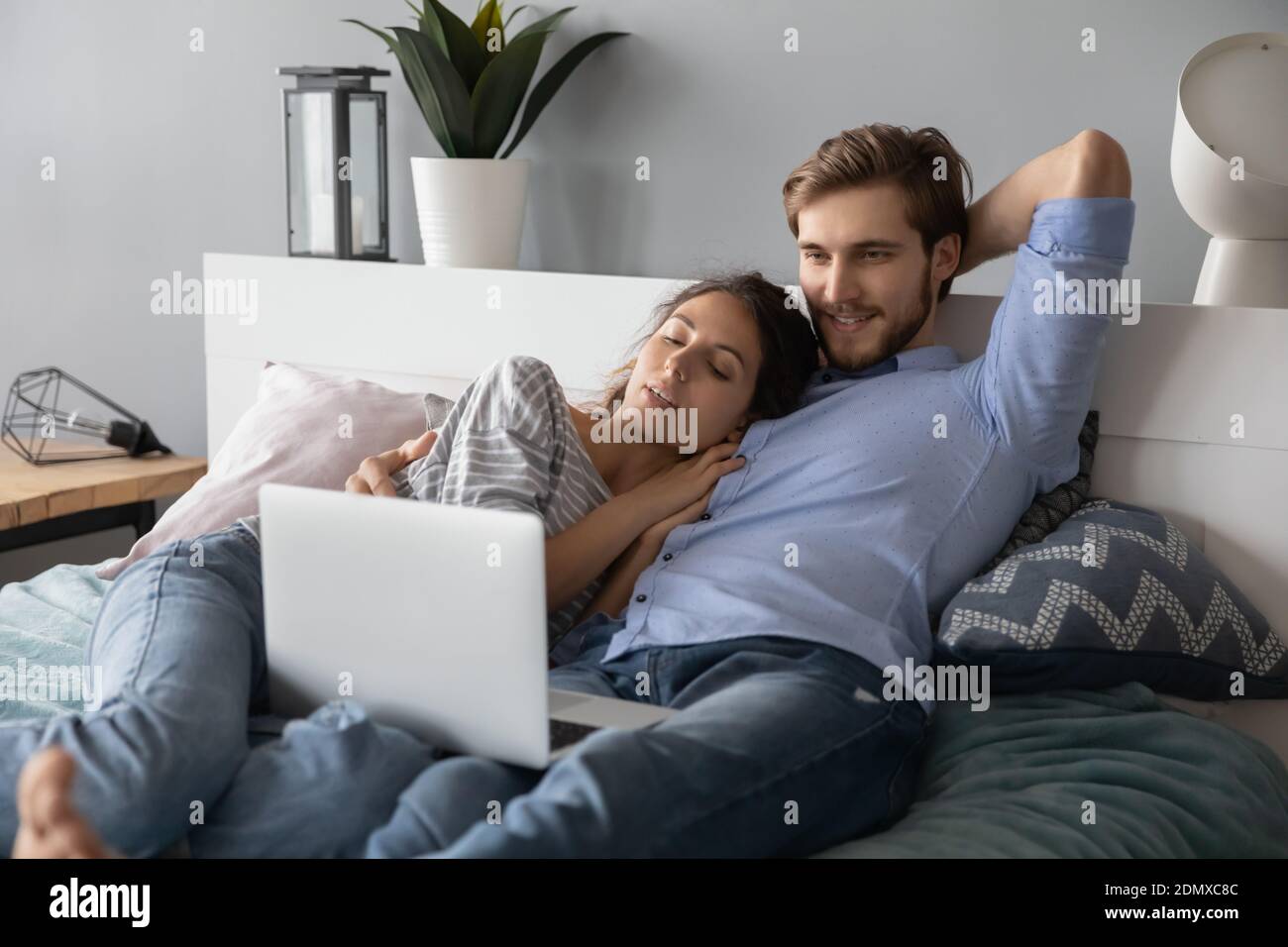 Happy couple cuddle in bed watching laptop Stock Photo Alamy