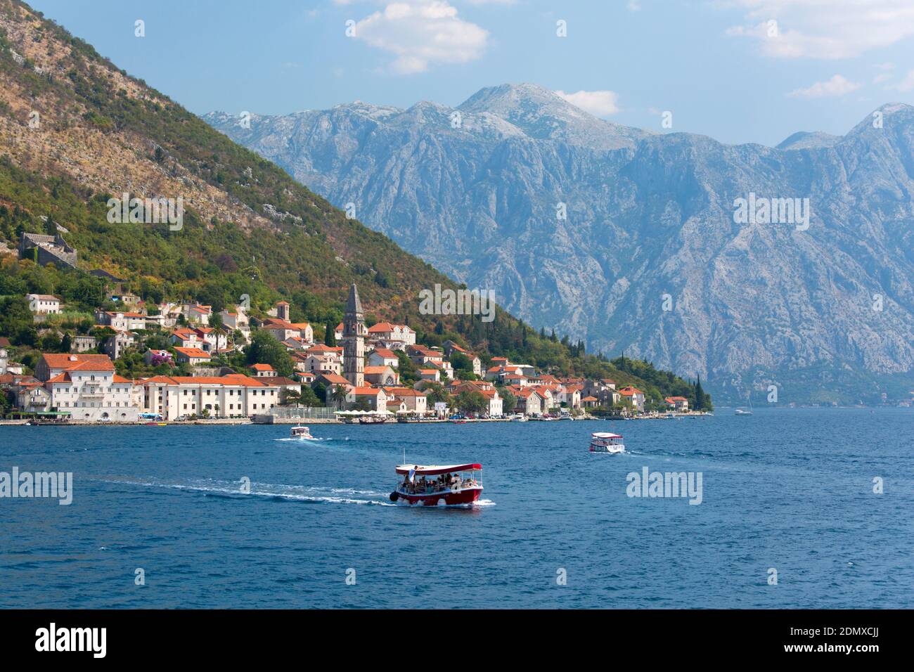 Perast, Kotor, Montenegro. Ferry boats shuttling tourists back and forth across the Bay of Kotor to the Church of Our Lady of the Rocks. Stock Photo