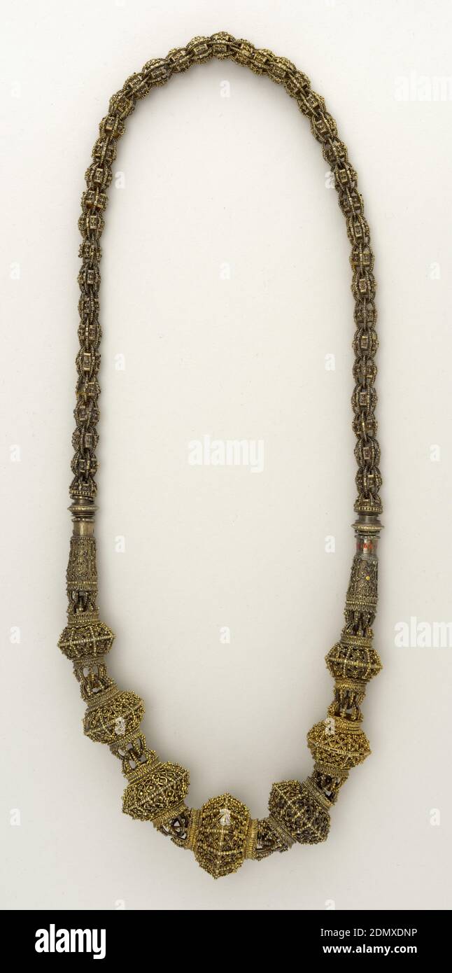 Necklace, Gilt silver, Necklace of gilt silver, made of two distinctly different designed parts. Lower part: seven 12-sided ridged globular units of filigree work and of graduating sizes. Connected by elongated bell-shaped unit to upper part of filigree braided links over circular, small-scaled units., Turkey, 19th century, jewelry, Decorative Arts, Necklace Stock Photo