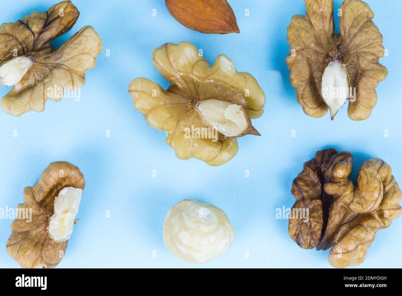 Nuts, walnuts, almonds and hazelnuts on a blue background, macro image Stock Photo