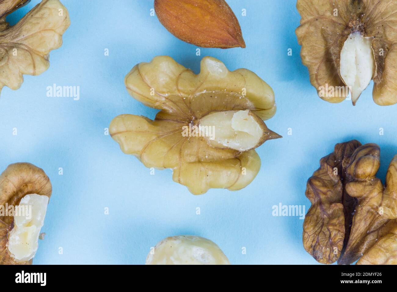 Nuts, walnuts, almonds and hazelnuts on a blue background, macro image Stock Photo