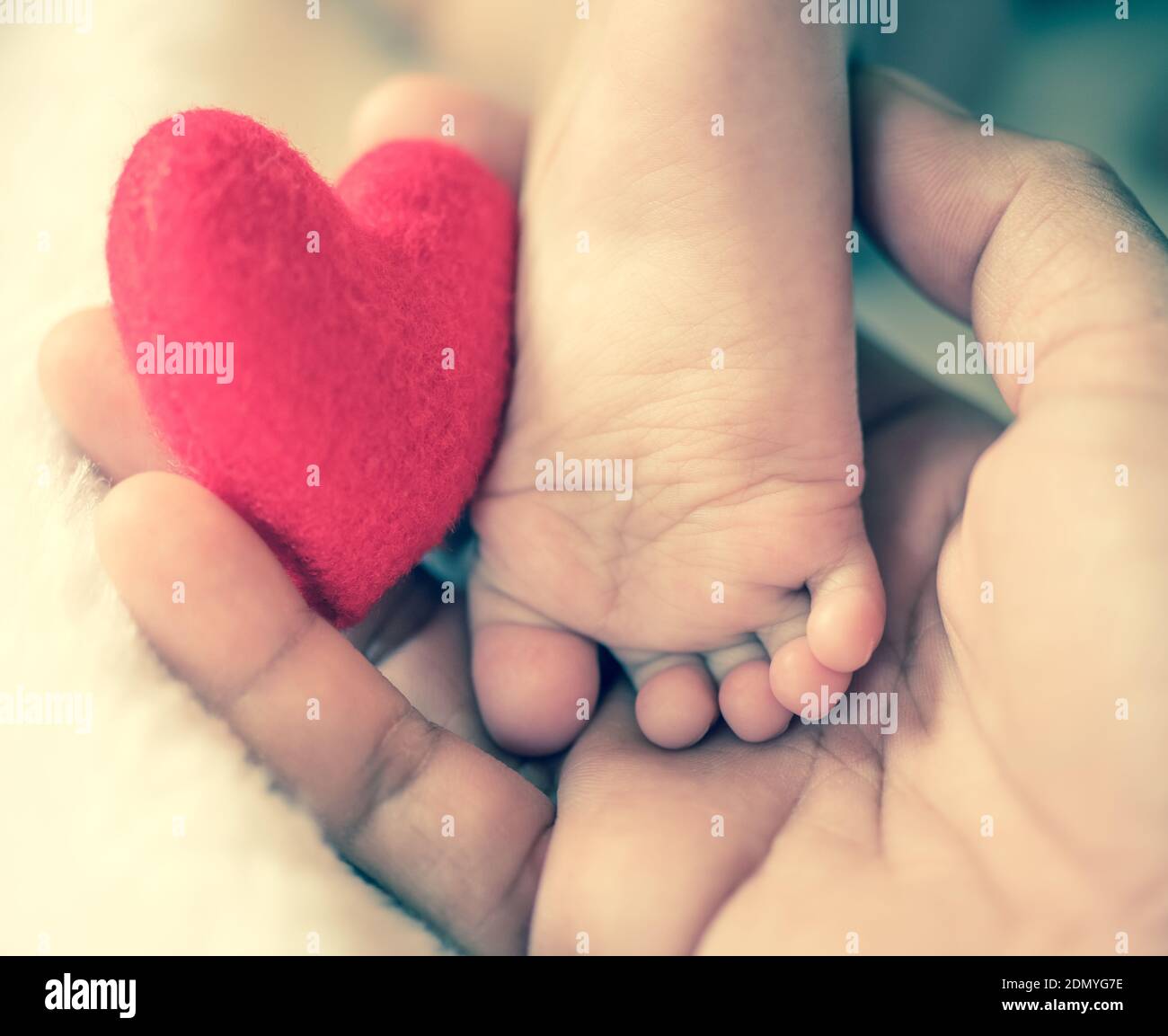Cropped Hand Of Person Holding Baby Foot With Red Heart Shape Toy Stock  Photo - Alamy