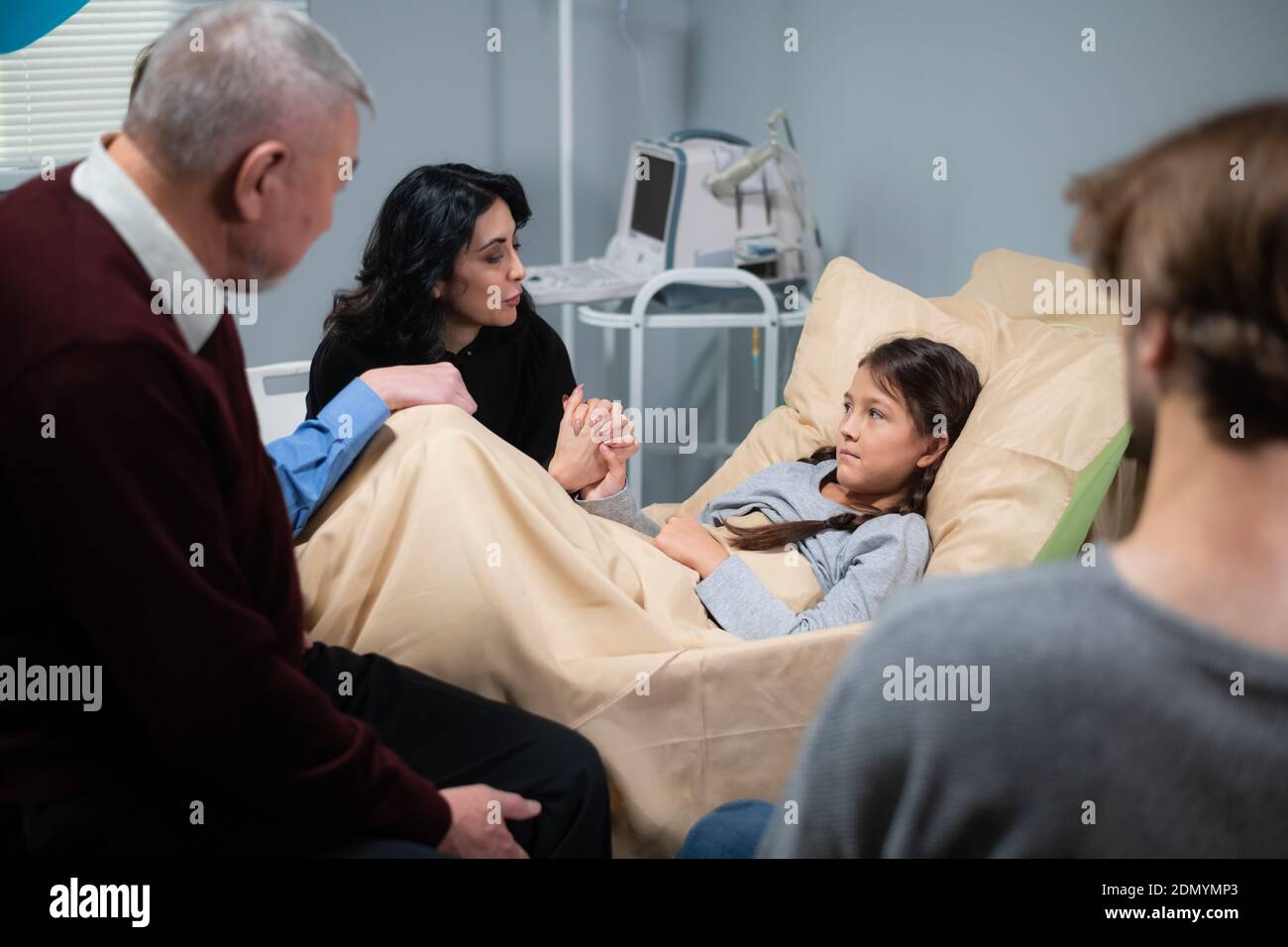 Healthcare concept - a family reunion in a hospital ward. Stock Photo