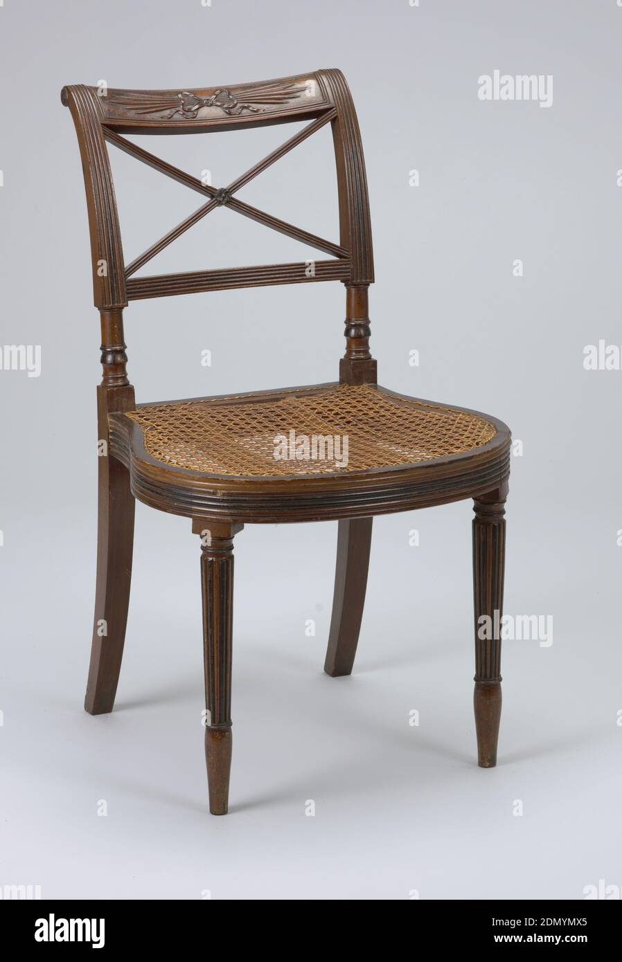 Side chair, Mahogany caned seat, Both chairs, rounded and reeded seat rail; rounded and reeded tapering legs. Top rail carved with 'thunderbolt design,' tied with bow. Below top rail, two diagonal, crossing bars, reeded., New York, USA, ca. 1812, furniture, Decorative Arts, Side chair Stock Photo