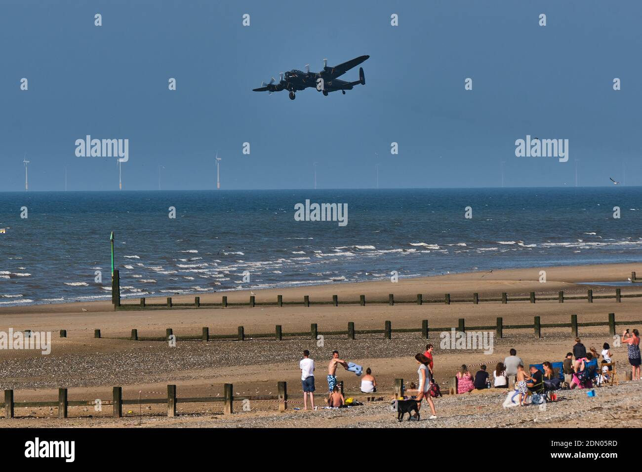 The Avro Lancaster of the Battle of Britain Memorial Flight makes a low, gear-down pass over the beach at the Rhyl Air Show 2019. Stock Photo