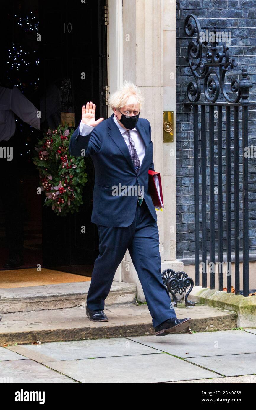 Prime Minister Boris Johnson leaves number 10 Downing Street waving, Christmas wreath on front door, Westminster, London, uk Stock Photo