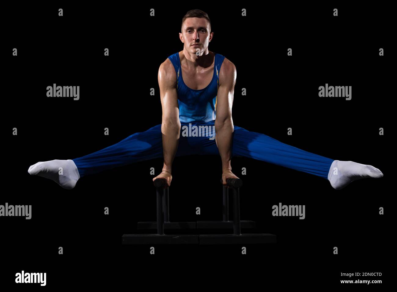 Target. Muscular male gymnast training in gym, flexible and active