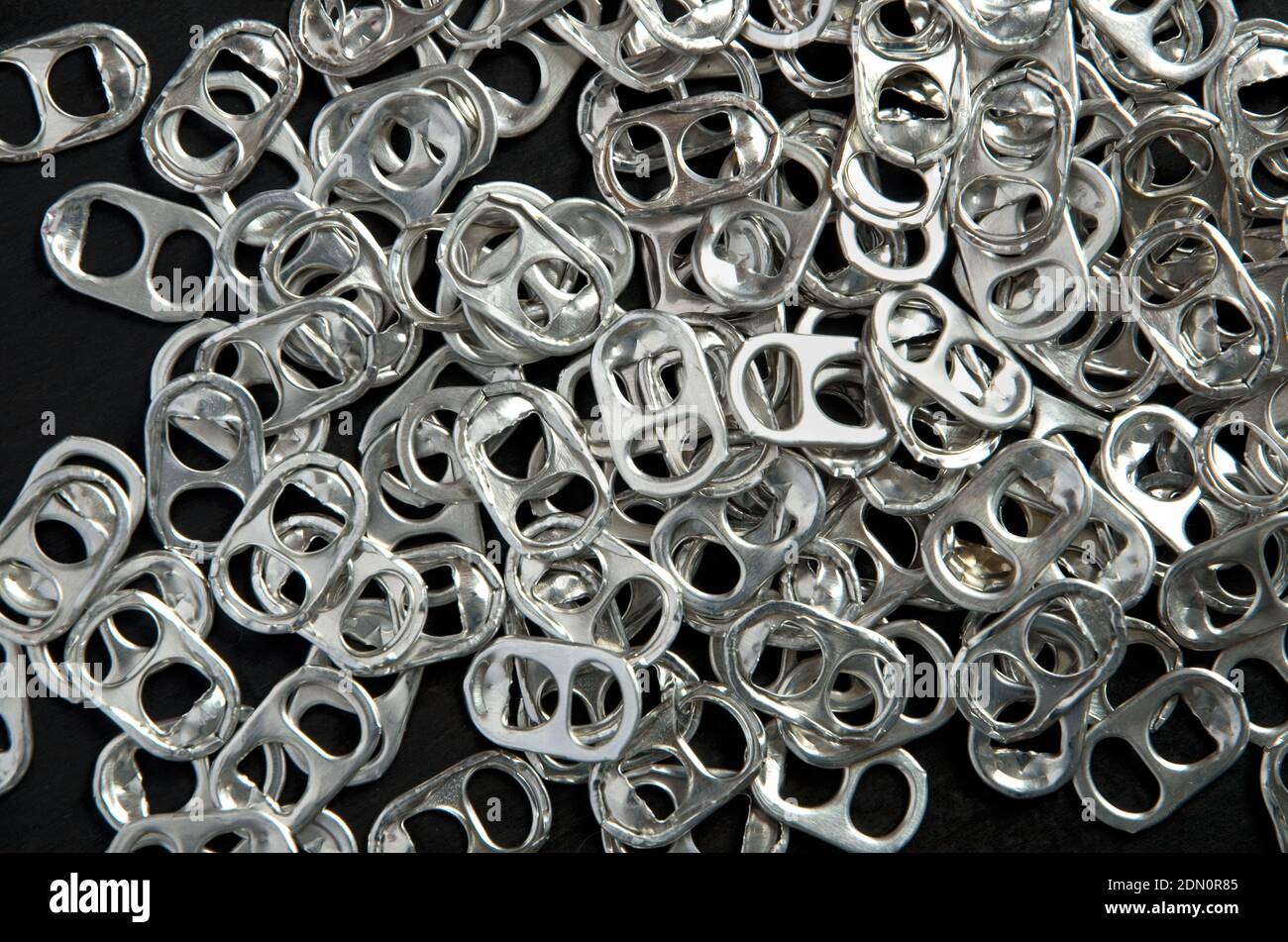 Recycling Beer and Pop Can Aluminum Tabs on Black Background Horizontal