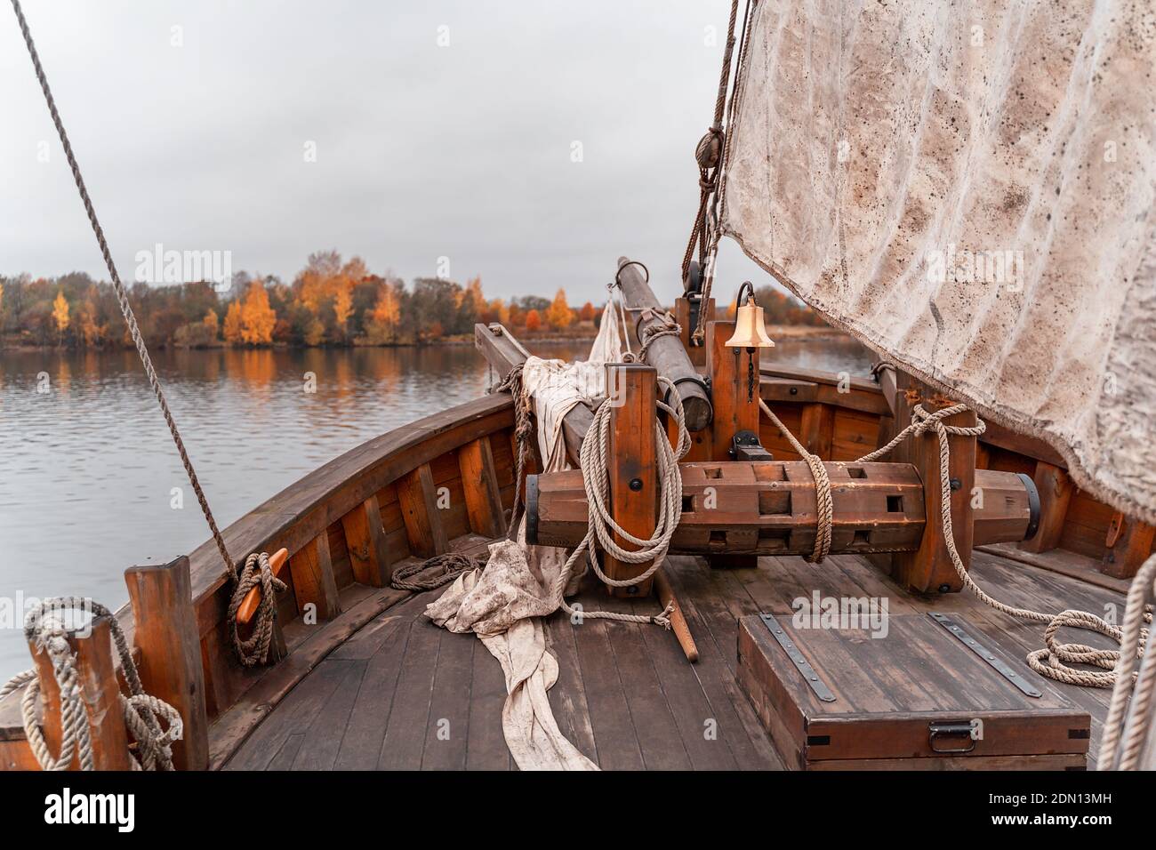 Wooden old ship in vintage style with all sails set in misty lake