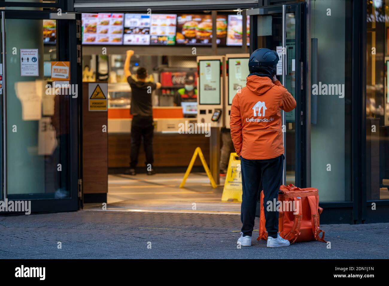 First day of the Christmas Lockdown in the Corona Crisis, Schildergasse shopping street, in the city centre, Lieferando delivery driver waits for a de Stock Photo