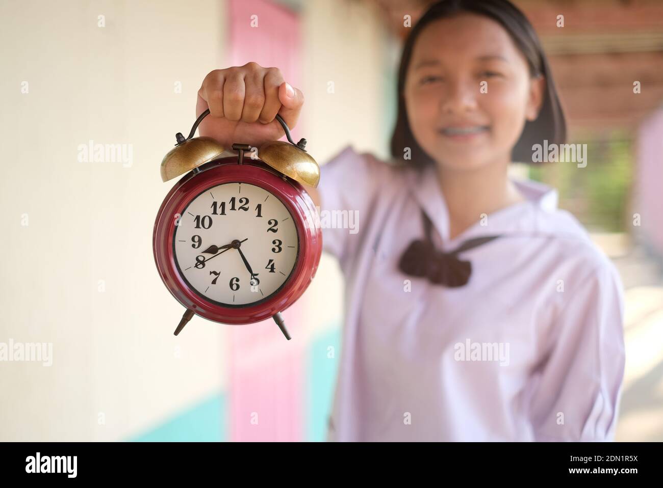 Portrait Of Teenage Girl Showing Alarm Clock Stock Photo Alamy