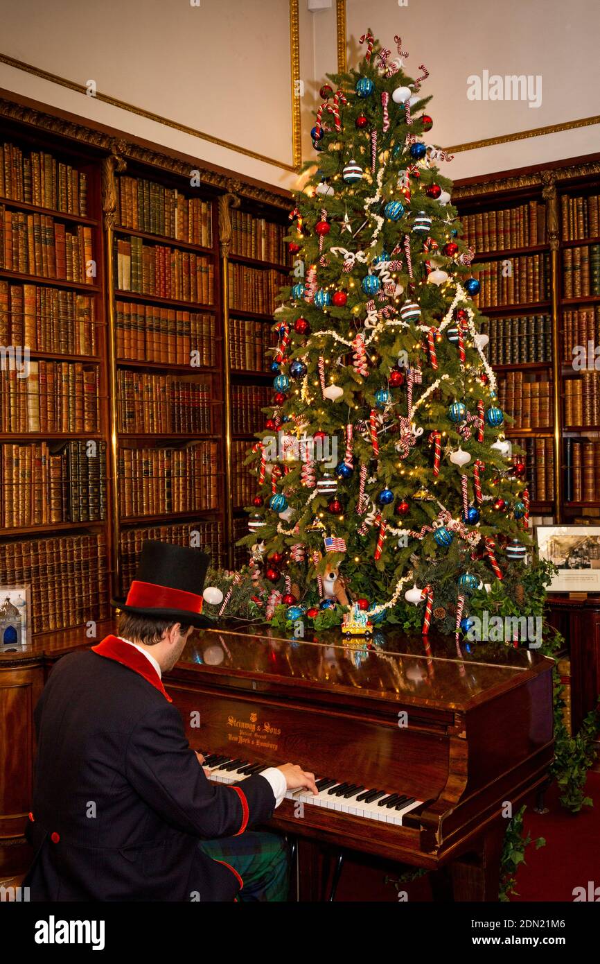 UK, England, Derbyshire, Edensor, Chatsworth House at Christmas, Ante-Library, uniformed man playing Steinway piano Stock Photo