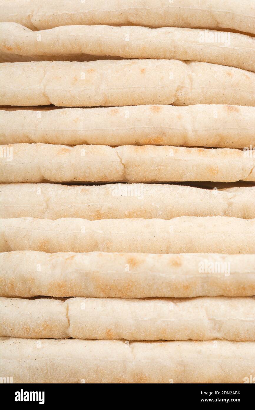 Pitta breads neatly stacked ready for re-heating and use in serve kebabs, souvaki, hummus. For flatbread, bread abstract, bread types, Greek food. Stock Photo