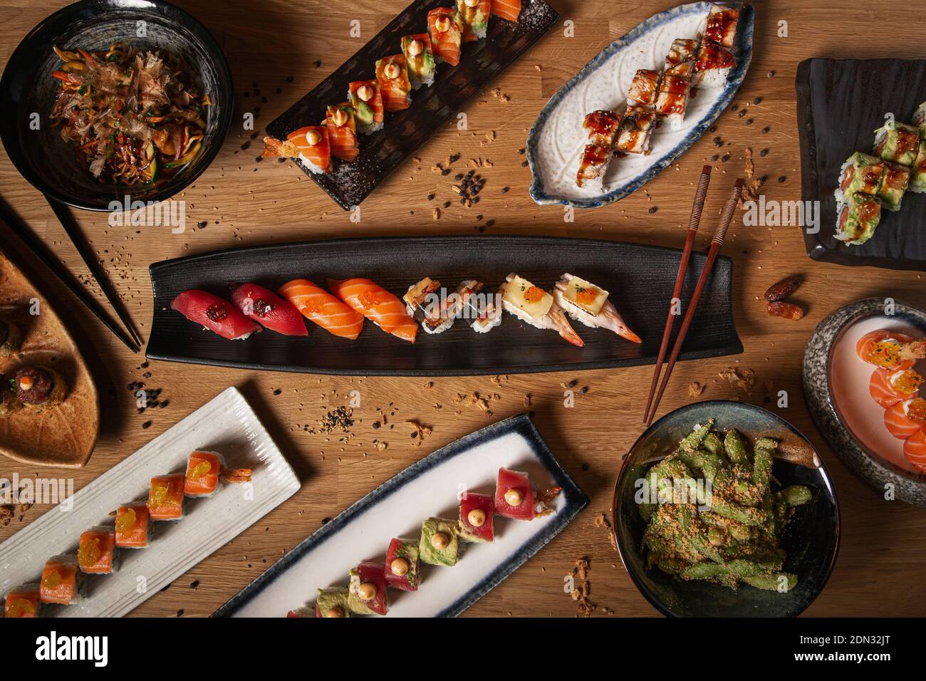 Image with various dishes of sushi, sashimi, nigiri, yakisoba and edamame on the restaurant table Stock Photo