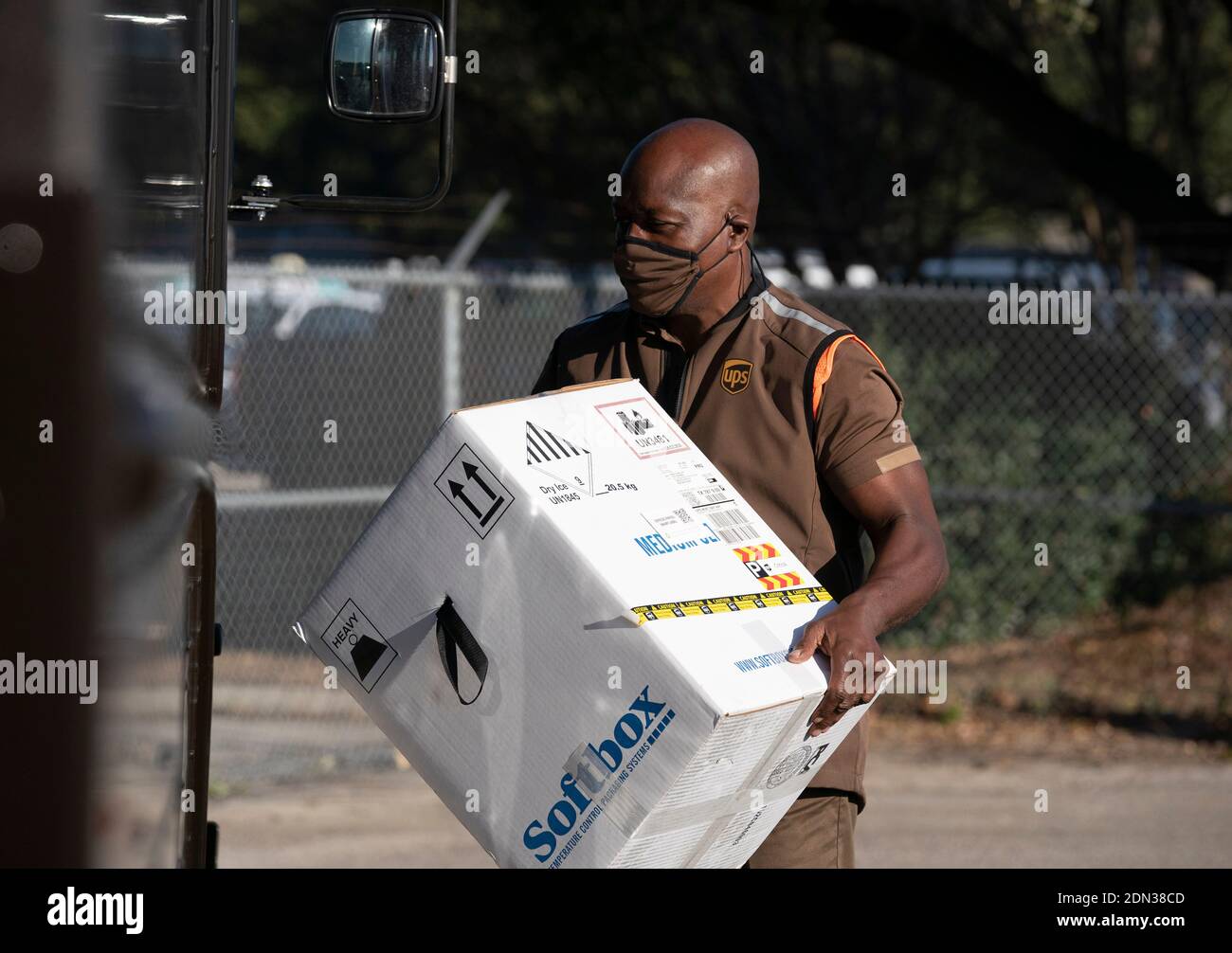 Austin, TX USA December 17, 2020: UPS driver Cornelius Littlejohn carries a box with 5,000 doses of vaccine during a press conference at a UPS facility where Texas officials touted the arrival of the state's first shipments of the Pfizer BioNTech anti-coronavirus vaccine. Thousands of Texans are expected to be vaccinated over the coming days. Credit: Bob Daemmrich/Alamy Live News Stock Photo