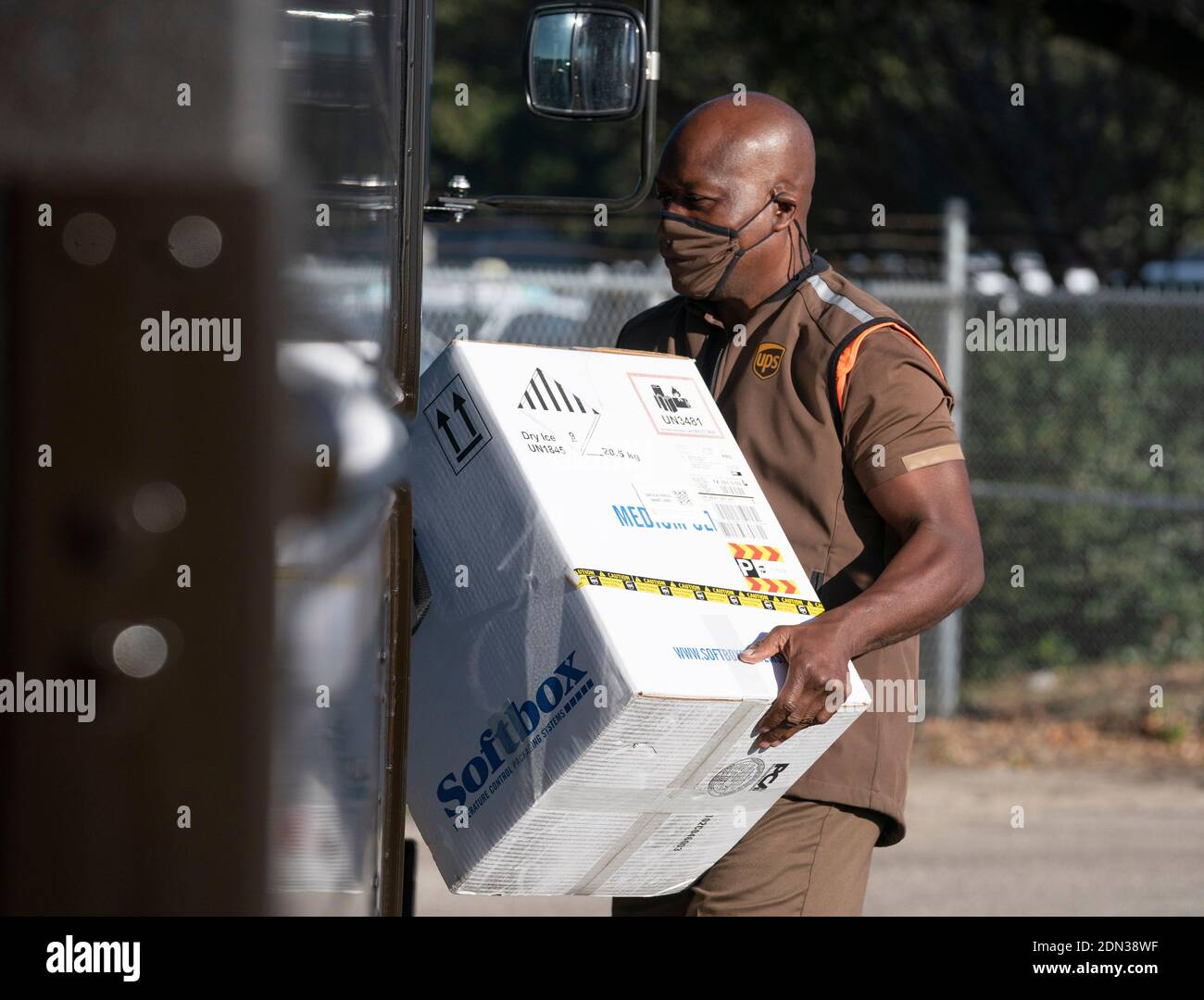 Austin, TX USA December 17, 2020: UPS driver Cornelius Littlejohn carries a box with 5,000 doses of vaccine during a press conference at a UPS facility where Texas officials touted the arrival of the state's first shipments of the Pfizer BioNTech anti-coronavirus vaccine. Thousands of Texans are expected to be vaccinated over the coming days. Credit: Bob Daemmrich/Alamy Live News Stock Photo