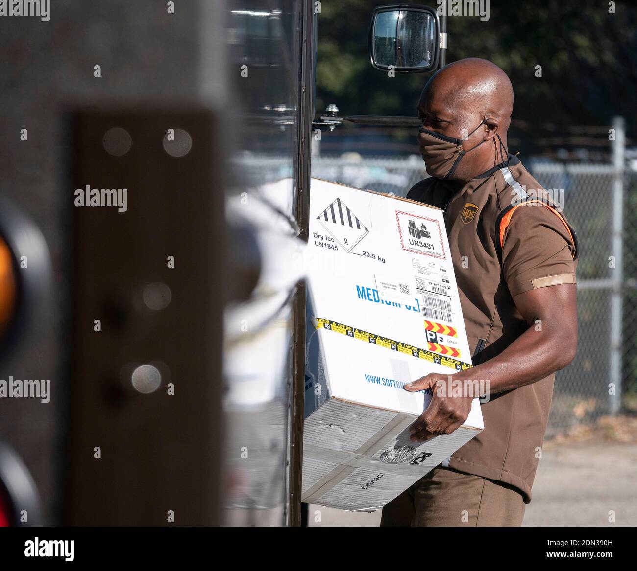 Austin, TX USA December 17, 2020: UPS driver Cornelius Littlejohn carries a box with 5,000 doses of vaccine during a press conference at a UPS facility where Texas officials touted the arrival of the state's first shipments of the Pfizer BioNTech anti-coronavirus vaccine. Thousands of Texans are expected to be vaccinated over the coming days. Credit: Bob Daemmrich/Alamy Live News Stock Photo