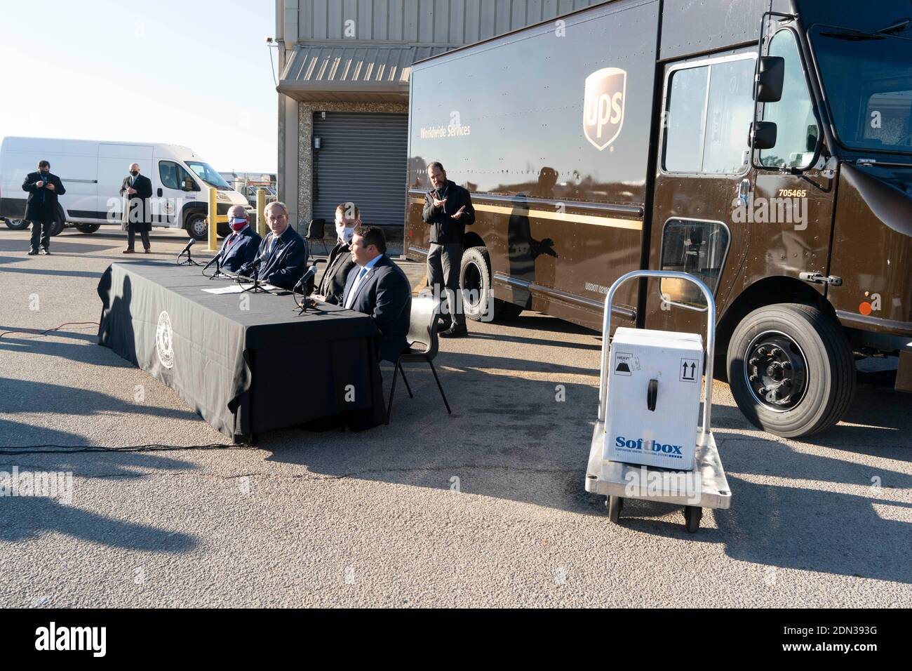 Austin, TX USA December 17, 2020: A box with 5,000 doses of vaccine awaits delivery as Texas Governor Greg Abbott (at table in background) talks at a UPS facility about Texas' receiving its first shipments of the Pfizer BioNTech anti-coronavirus vaccine. Thousands of Texans are expected to be vaccinated over the coming days. Credit: Bob Daemmrich/Alamy Live News Stock Photo