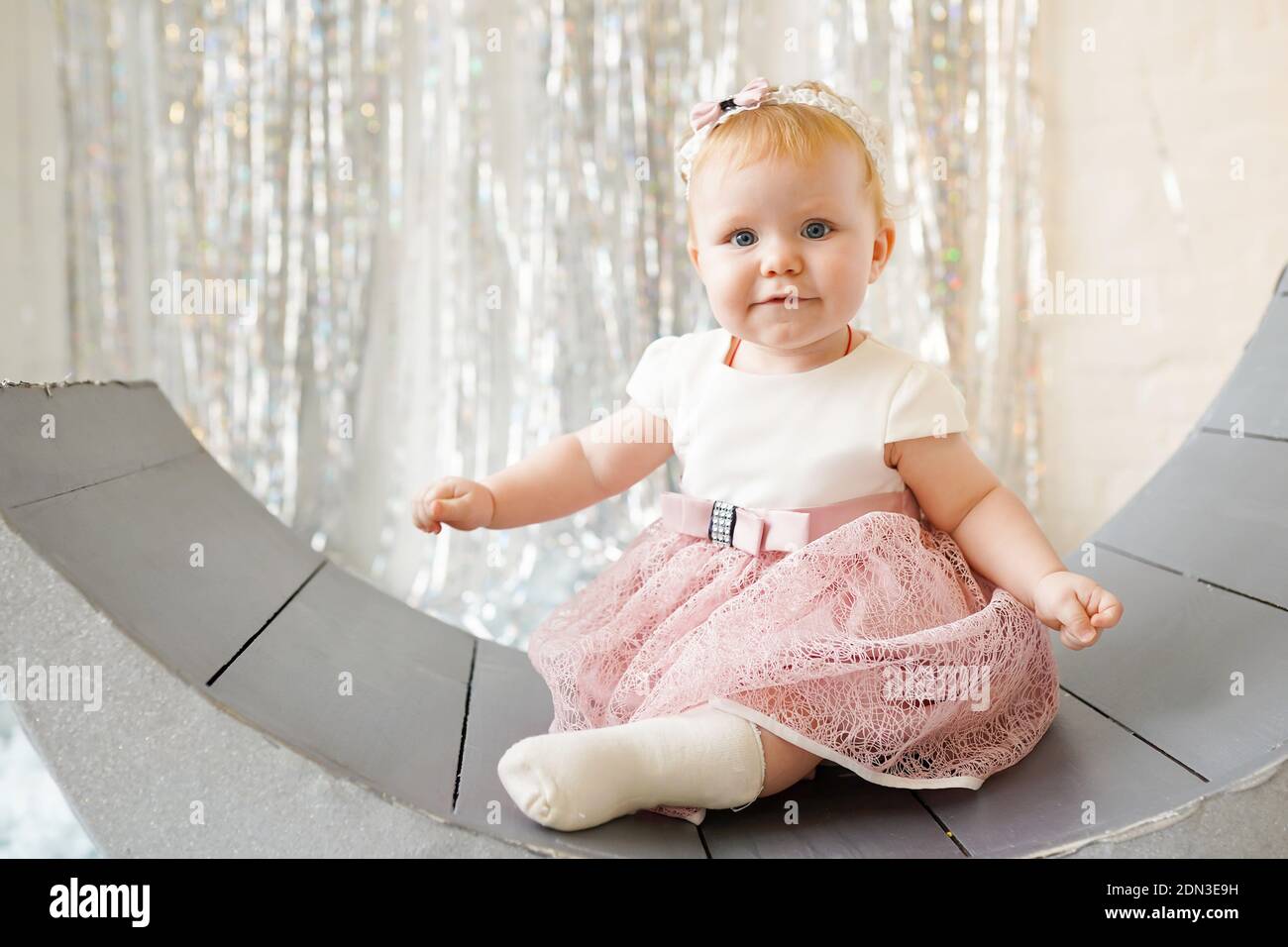 Charming little baby girl in nice pink dress, looking like a smiling ...