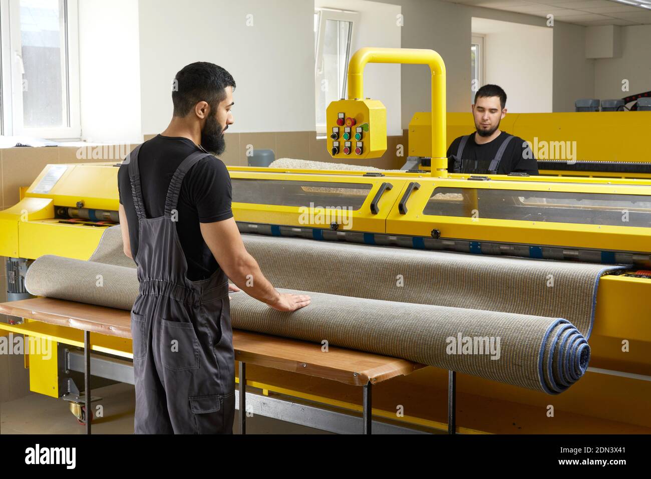 Two man operating professional cleaning equipment in laundry service ...