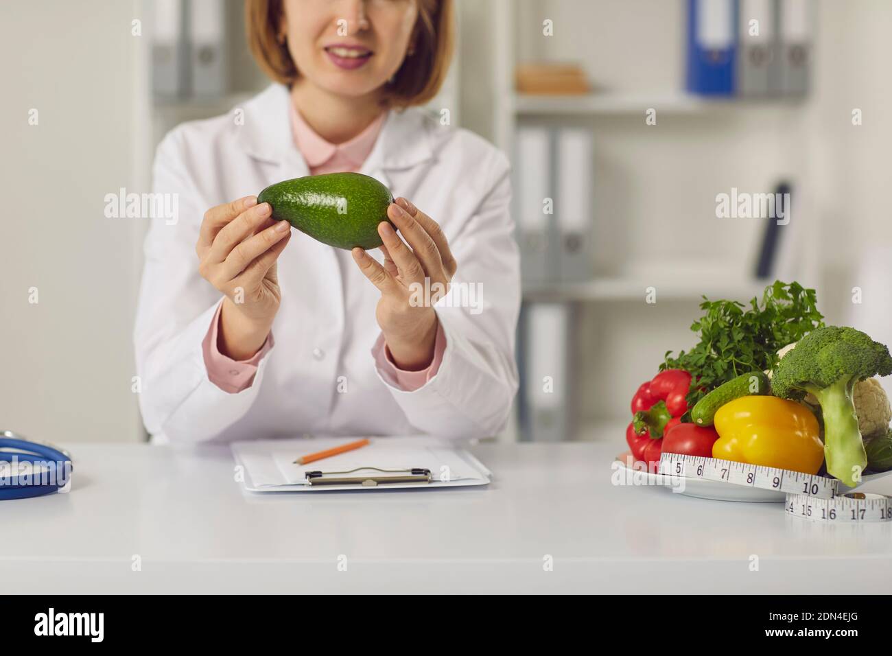 Woman doctor nutritiologist speaking about benefits of healthy fresh vegan diet for slimming online Stock Photo