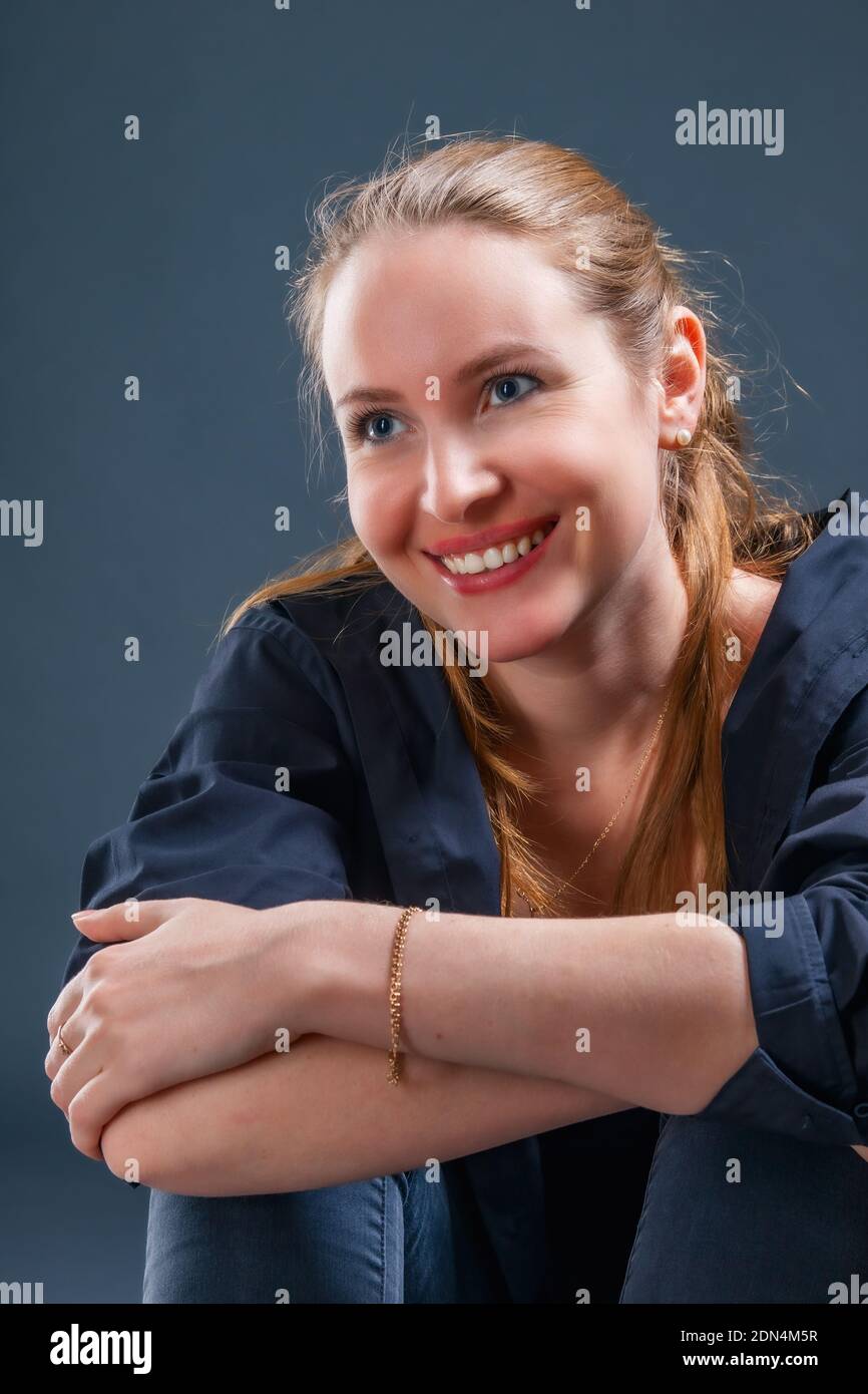 Very positive smiling young blonde woman sitting on the floor Stock ...