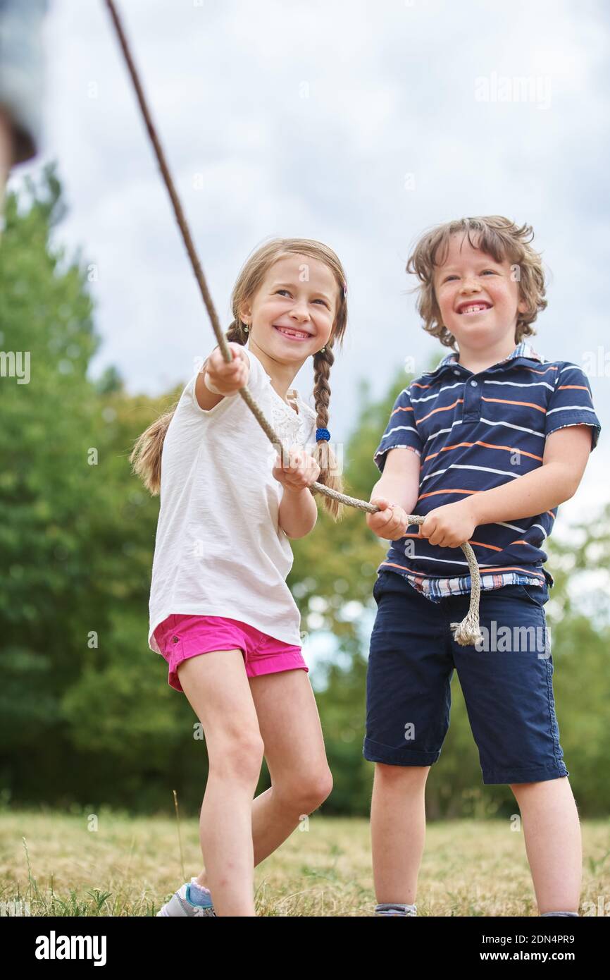 Smiling Friends Pulling Rope On Field Stock Photo Alamy
