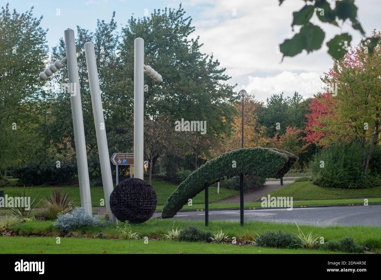 Large sculpture of cricket ball striking wicket and bails coming off with middle stump askew set near entrance to Durham County Cricket Ground Stock Photo