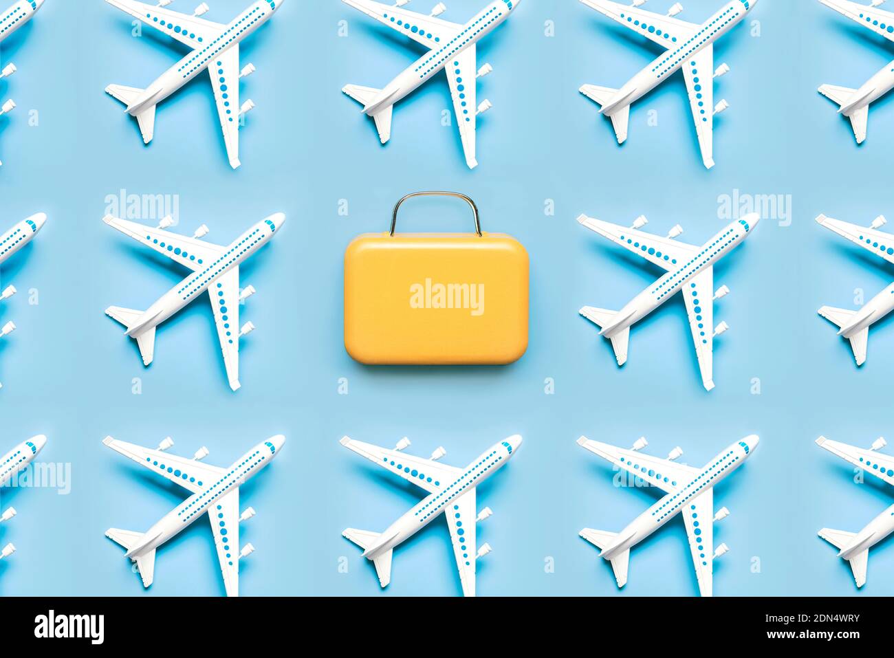 Geometric pattern made with airplane and suitcase on blue background.Holidays and travel concept Stock Photo
