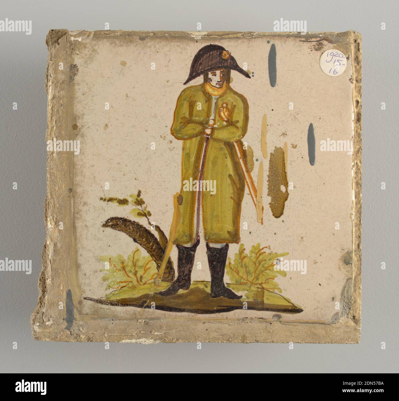Tile, Earthenware, glazed and high fire decorated, Soldier in black boots, green coat and bicorn hat, clutching a sword under his left arm. Tree trunk with a few leaves at the left., Alcora, Spain, late 18th–early 19th century, tiles, Decorative Arts, Tile Stock Photo