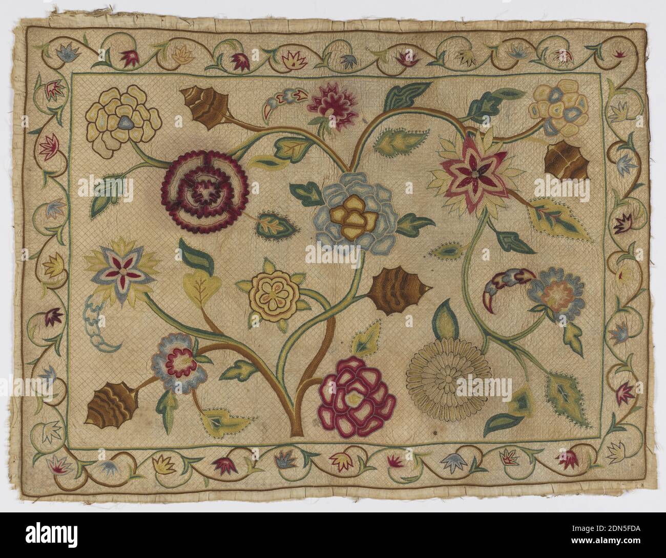 Pillow cover, Medium: silk on cotton Technique: chain, back, knot and stem stitch embroidery on plain weave; quilted, Horizontal panel filled with fantastic flower heads, leaves, spreading branches of a small flowering tree, narrow border on four sides with running floral scroll. In polychrome silk chain stitch on undyed cotton ground with fine quilting in beige silk outline stitch on diamond framework. Details in knot, buttonhole, outline sittch., England, ca. 1700, embroidery & stitching, Pillow cover Stock Photo